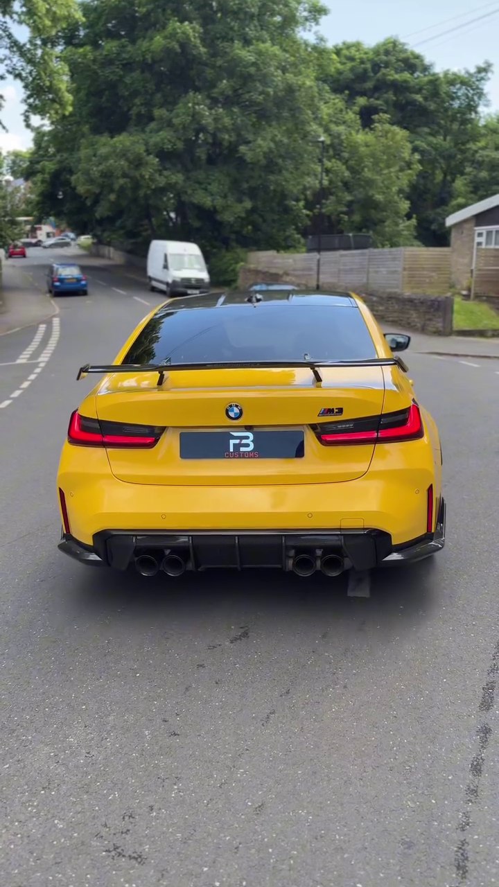 Rear view of a yellow BMW M3 on a road