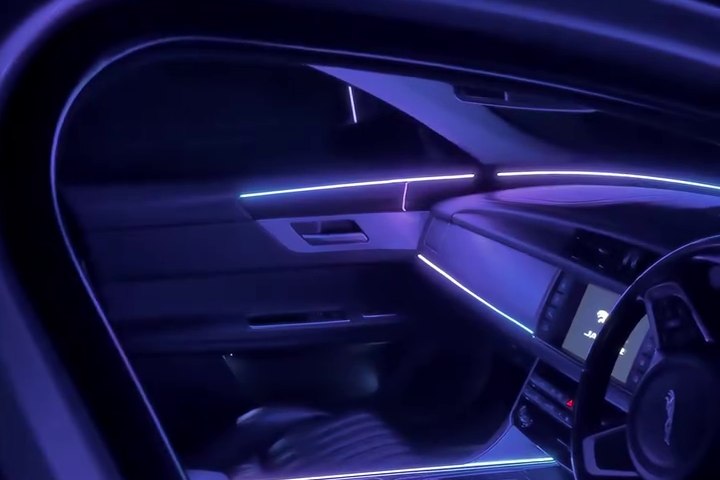 Blue and violet ambient lighting along a vehicle dashboard and door