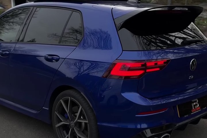 Rear three-quarter view of a blue Volkswagen with dark windows